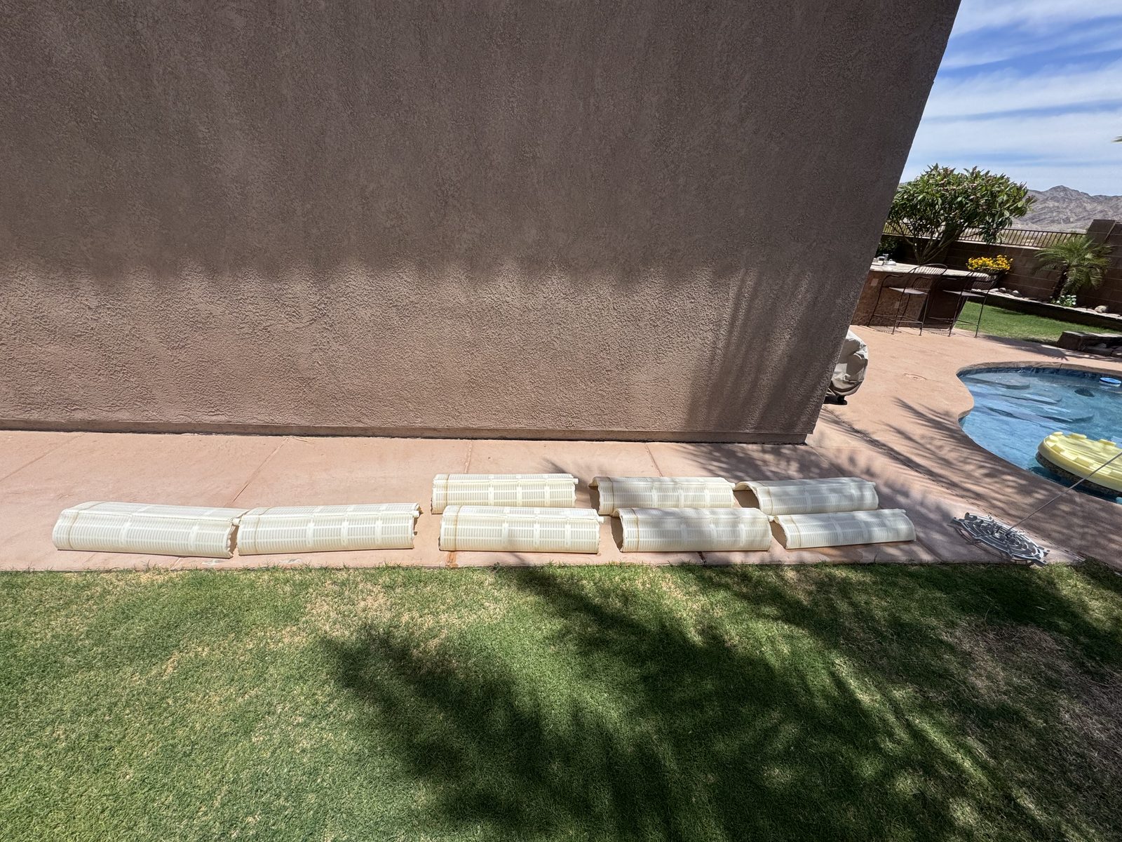 Pool filter grids laid out on the patio during a filter cleaning in Yuma, AZ
