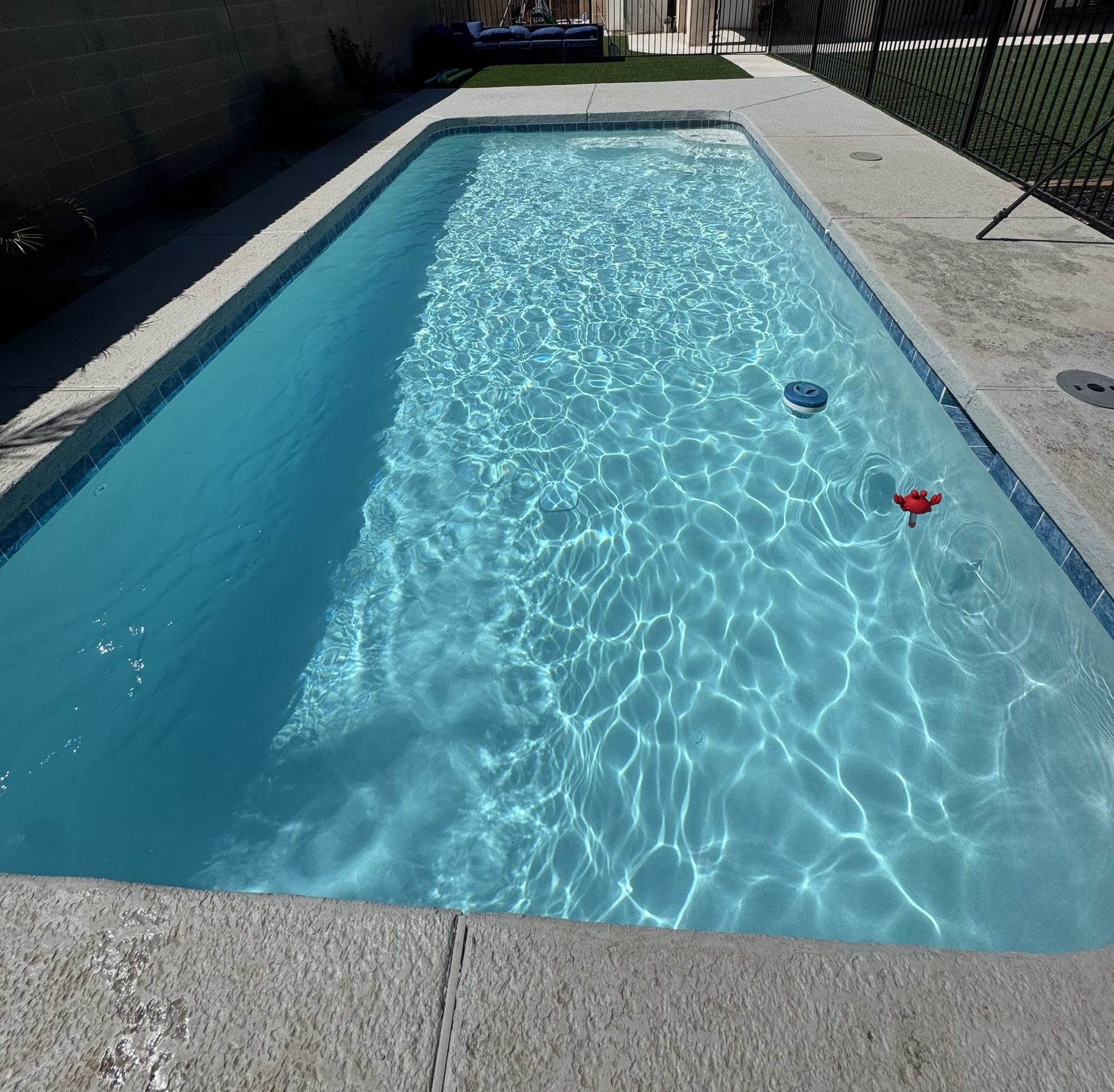 Crystal-clear blue backyard pool after weekly pool maintenance in Yuma, Arizona